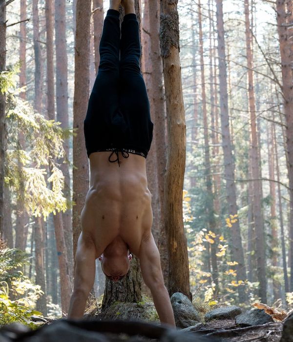 Man performing a bodyweight exercise in a dark, focused environment.